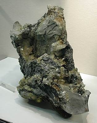 Grosse Quarzgruppe - Albulawerke GR, (HxBxT: 50x20x40cm). Die Kristalle sind teils mit einer dünnen Limonitschicht bedeckt und von Calciten begleitet.