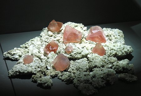 9 Rosa-Fluorit-Kristalle| auf Granit ausgelegt; KB: bis 7cm; Fundort: Planggenstock, Göscheneralp (UR)